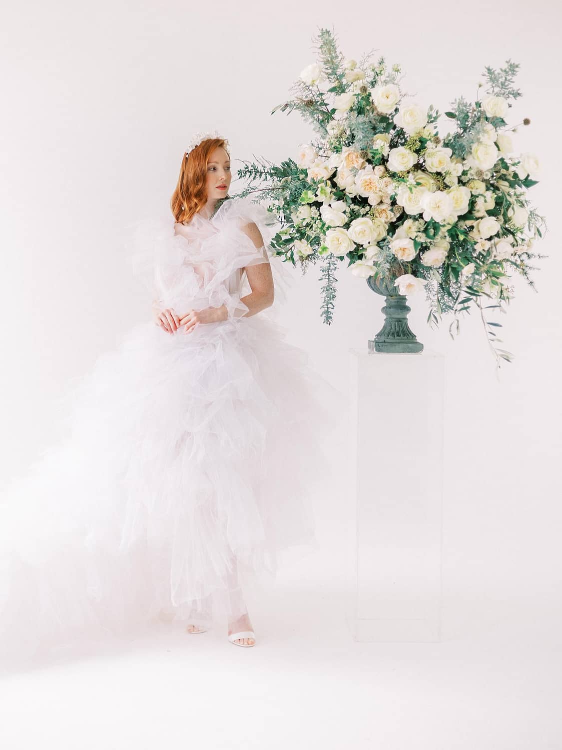 Mariée en robe de mariée à volants à côté de l'arrangement floral