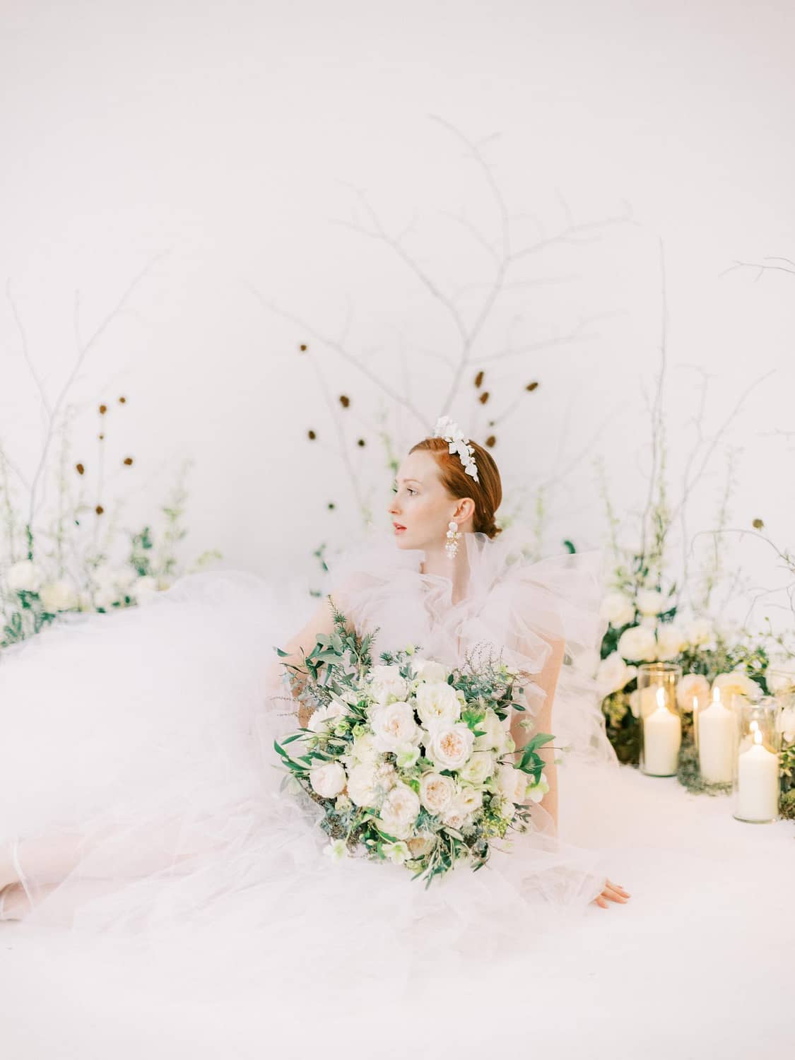 Mariée en robe de mariée blanche à volants avec bouquet de mariée