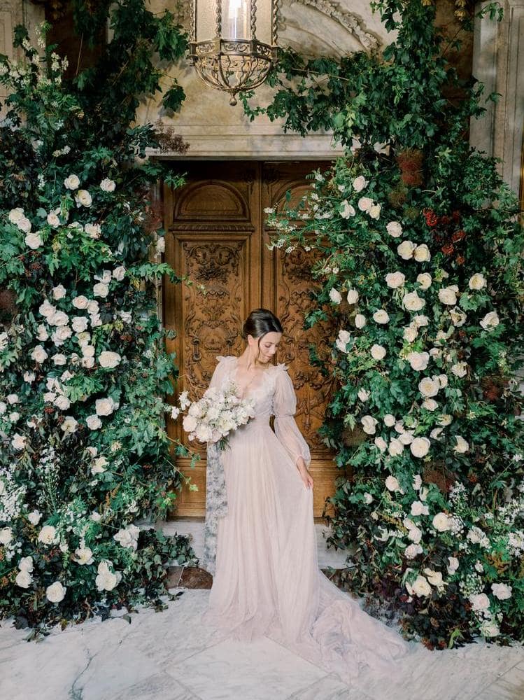 Mariée avec bouquet de mariée et arche florale