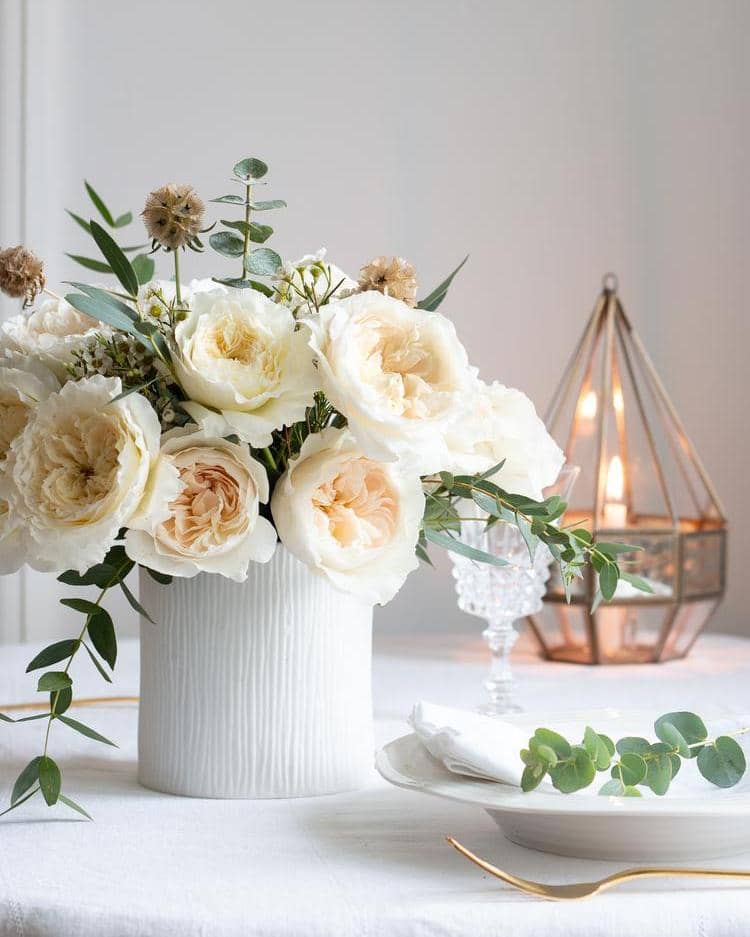 Weiße weihnachtliche florale Tischdekoration mit weißen Rosen