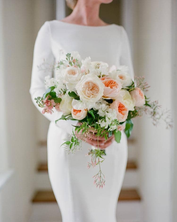 Sposa che tiene il bouquet da sposa David Austin Roses