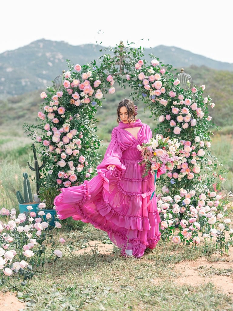 Hochzeit im Freien mit rosa Blumenbogen