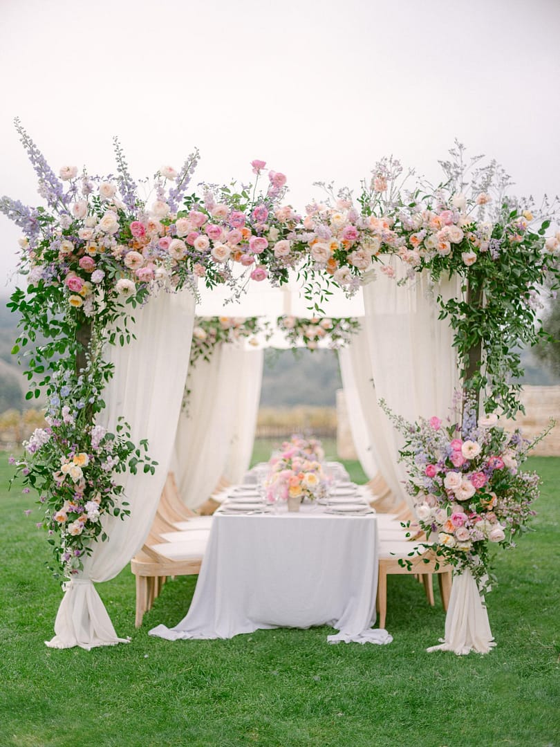 vista horizontal de hermosas flores artificiales en colores rosa y púrpura  en jarrones blancos en los stands en el salón para la ceremonia de boda.  decoración floral 11563162 Foto de stock en