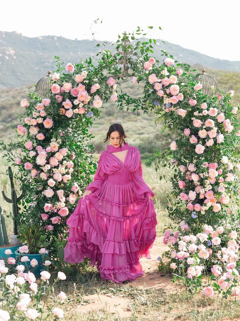 novia bajo el arco floral de la boda