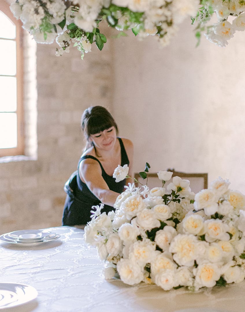 Floristería haciendo arreglos de mesa de boda